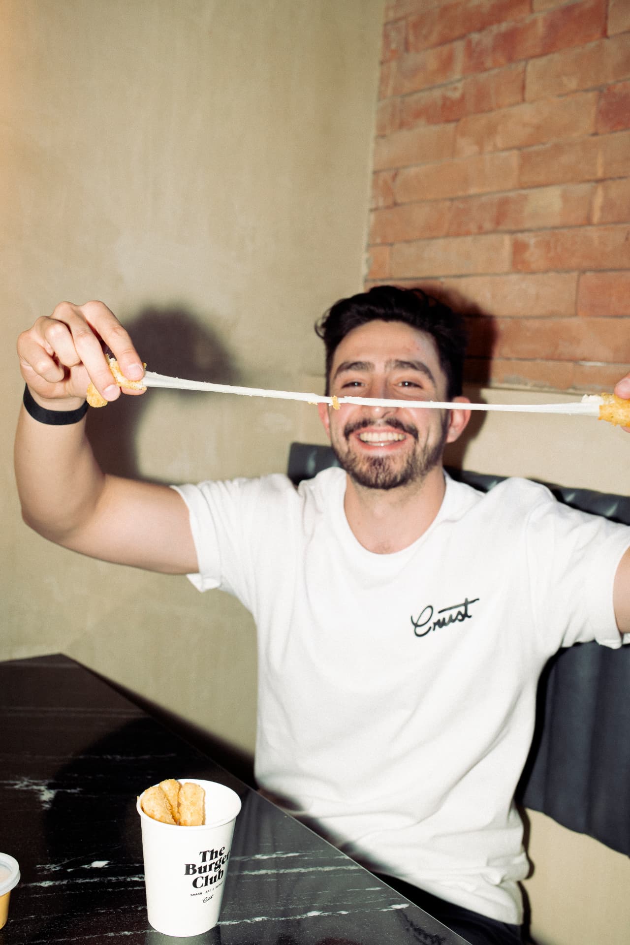 Cliente disfrutando los mozzarella sticks de Crust